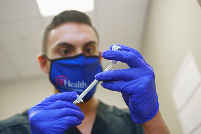 A member of the pharmacy team draws one of the first doses of the COVID-19 vaccine in preparation for UF Heath Central Florida’s first vaccination clinic.