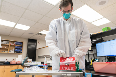 Clinical Lab Scientist Raymond LaRue sorts through stat COVID-19 tests in the core lab of UF Health Shands Hospital in Gainesville, Florida. — © UF Health, Photo by Louis Brems