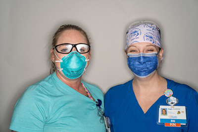Front-line health care providers Kellie Mcleod, R.N., and Stephanie Tussey, R.N., pictured here at the end of a 12-hour shift in the UF Health Shands E.R. — © University of Florida, Photo by Jesse S. Jones