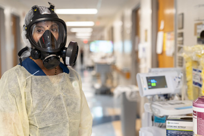 Nika S. Radhakrishnan, M.D., chief of the division of hospital medicine at UF Health Shands Hospital, dons full PPE to treat patients on a COVID-19 unit. The use of extensive PPE was an adjustment for patients as well as clinical care providers. — © University of Florida, Photo by Jesse S. Jones