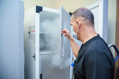 Paul Sullivan, Pharm.D., pharmacy director for UF Health Leesburg Hospital, prepares one of the ultra-low-temperature freezers to store the Pfizer/BioNTech COVID-19 vaccine.