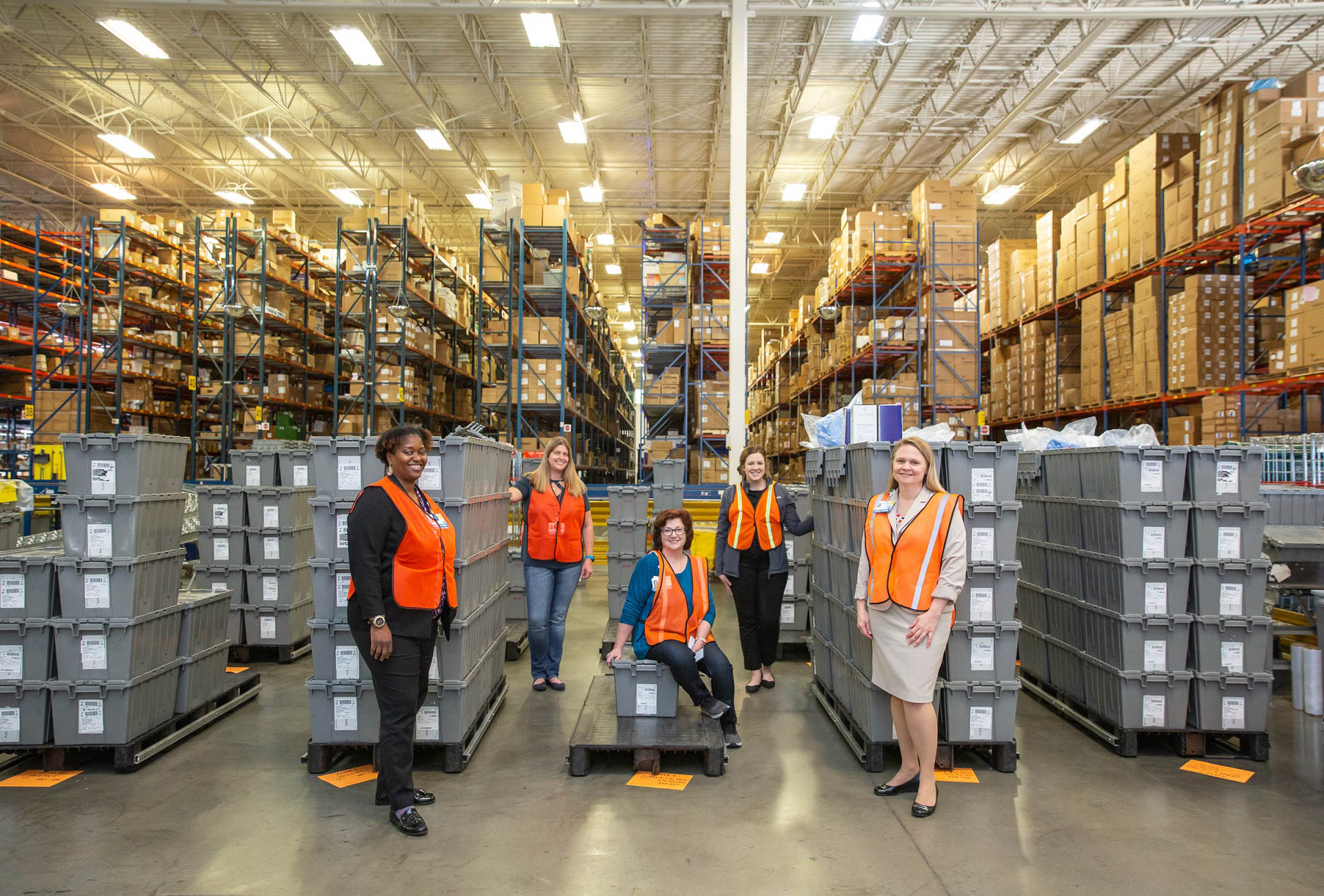 The UF Health Integrated Service Center (ISC) leadership team provides a view into their distribution center where totes are staged for delivery to the front lines.