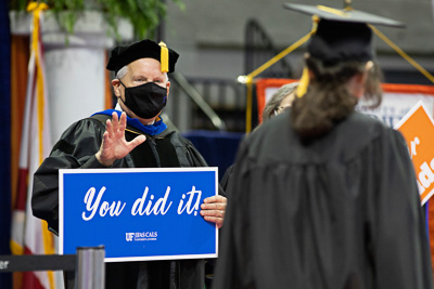 After a hiatus of in-person comencements, in the summer of 2021, University of Florida seniors, masters and PhD recipients were able to finally walk across the stage at Exactech Arena to get their diploma. The excellence of UF as a premiere institution of higher learning is exhibited in all of its graduates, who showed tremendous resilience and perserverence in the face of challenging and unprecedented circumstances brought on by the global COVID-19 pandemic. Masked and physically distanced from one another, the 2021 commencements were like none other, yet students would not be denied their moment of recognition. — © 2020 UF/IFAS Communications, Photo by Tyler Jones