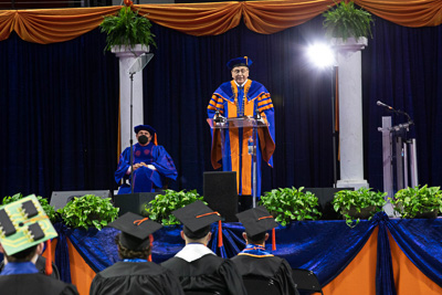 Graduations had been halted for over a year due to COVID 19. In Spring 2022, commencement celebrations returned complete with President Fuchs delivering 28 speeches to approximately 6500 UF grads and their families in socially distanced ceremonies. “You have gone the distance - at a distance. You have triumphed over a historic challenge. You are the first to have in-person graduation ceremonies amid this pandemic. I am so happy to see you in all three dimensions. Congratulations!” - President Fuchs