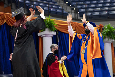 Graduations had been halted for over a year due to COVID 19. In Spring 2022, commencement celebrations returned complete with President Fuchs delivering 28 speeches to approximately 6500 UF grads and their families in socially distanced ceremonies. “You have gone the distance - at a distance. You have triumphed over a historic challenge. You are the first to have in-person graduation ceremonies amid this pandemic. I am so happy to see you in all three dimensions. Congratulations!” - President Fuchs