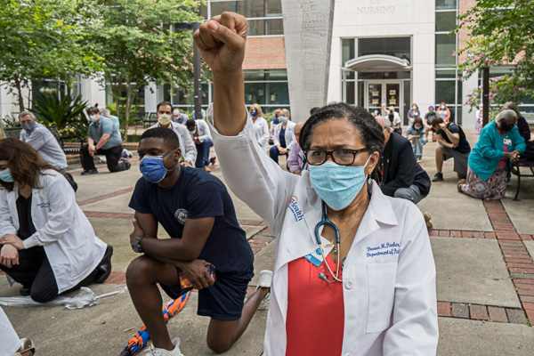 Image: During the summer of 2020, while everyone was still attempting to adjust to the realities of the pandemic, there was an explosion of protests after the killing of George Floyd. In a demonstration of solidarity with the social justice movement, faculty, staff, and students held a White Coats for Black Lives demonstration in the Academic Health Center. Participants from all six colleges and UF Health took a knee and observed a moment of silence for 10 minutes - © University of Florida, Photo by Jesse S. Jones - © University of Florida, Photo by Jesse S. Jones